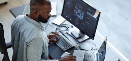 business analyst working with data on two screens